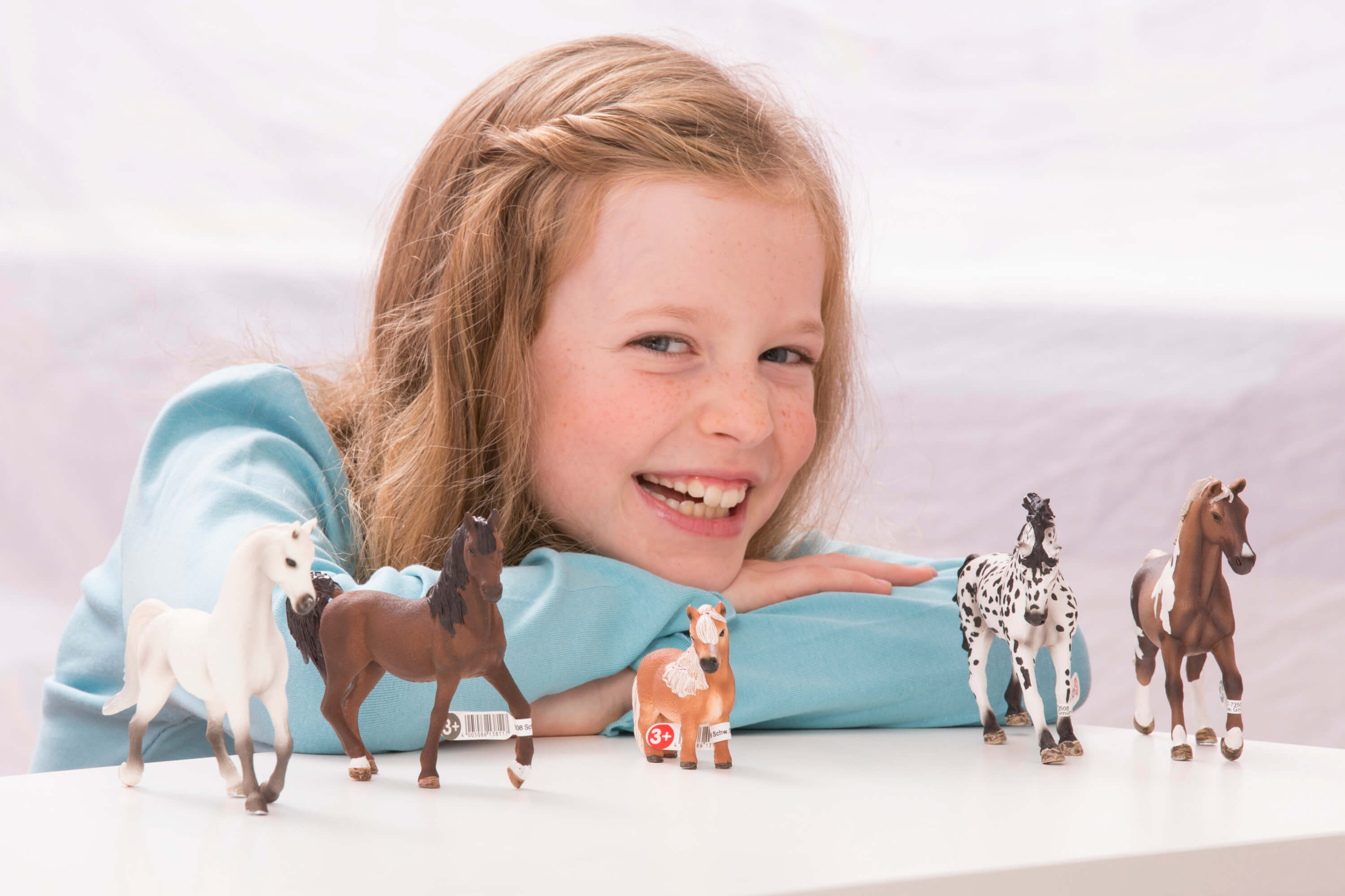 Schleich horse toys being played with by young girl.