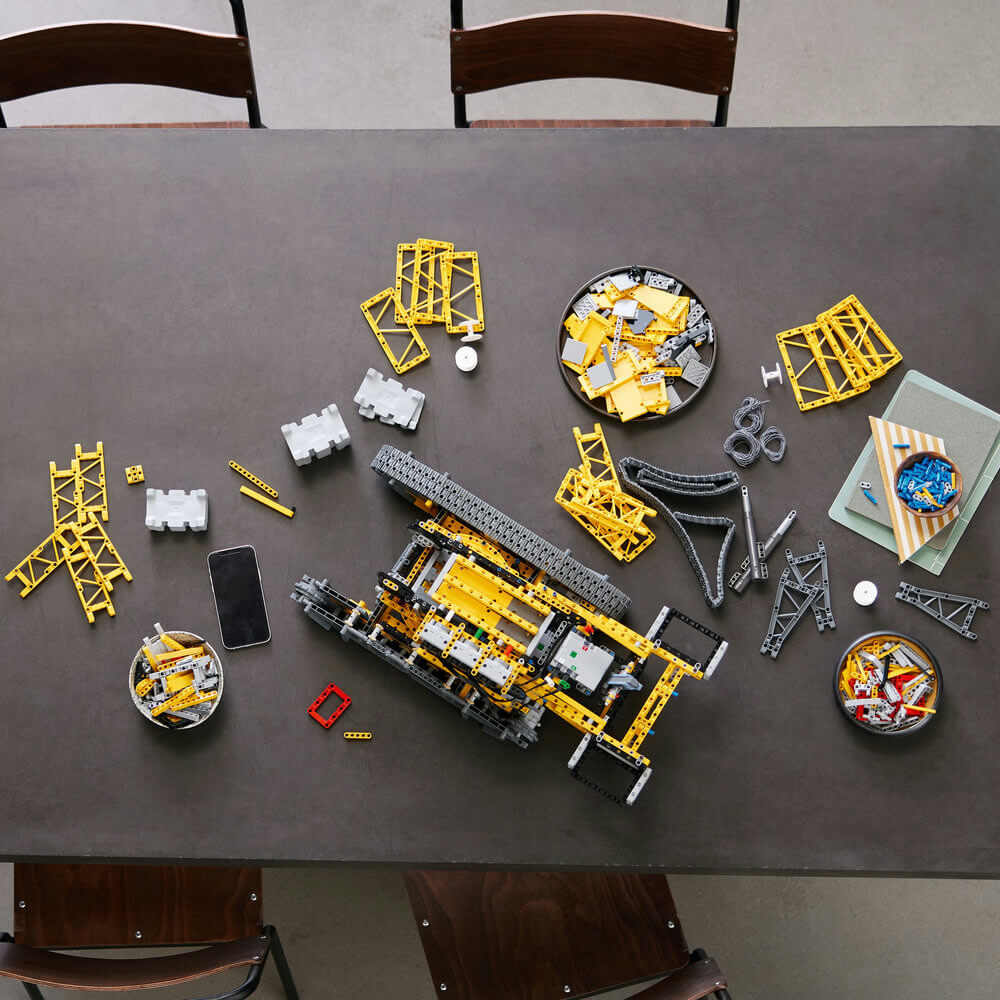 pieces of the LEGO® Technic™ Liebherr Crawler Crane LR 13000 42146 Building Kit (2,883 Pieces) with part of it assembled