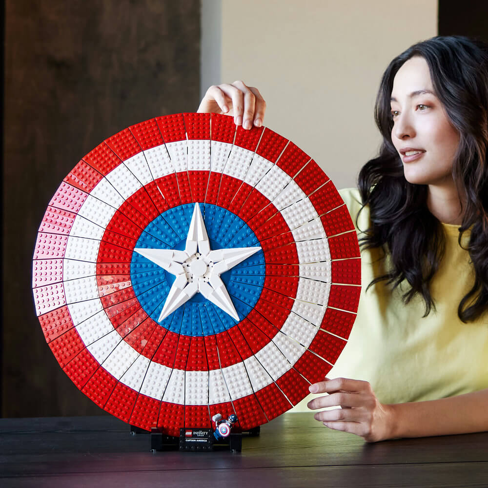 Woman admiring the completed LEGO® Marvel Captain America’s Shield 76262 Building Kit (3,128 Pieces)
