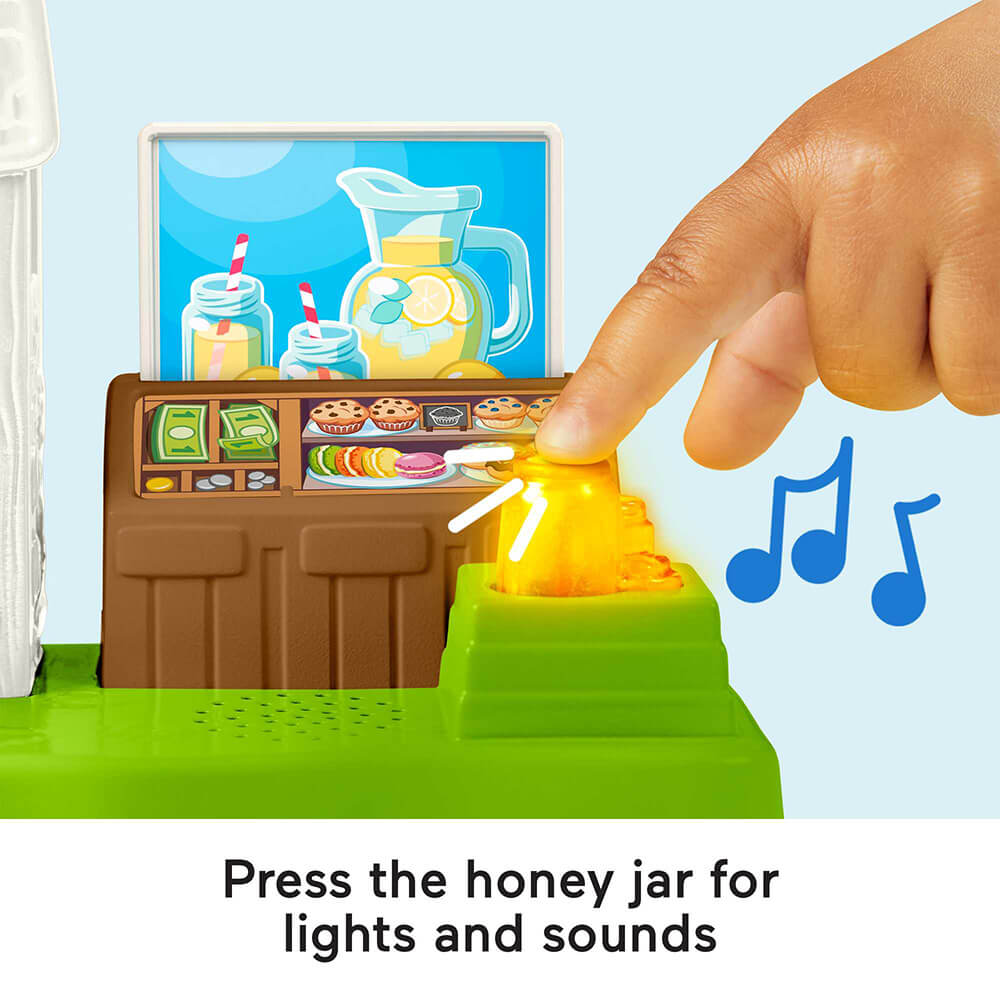 Press the honey jar for lights and sounds in the Fisher-Price Little People Lemonade Stand Playset
