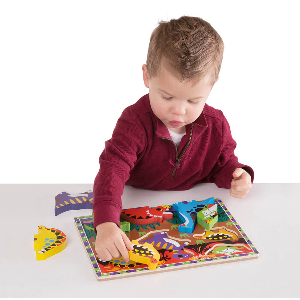Boy completing the Melissa and Doug Dinosaurs 7 Piece Chunky Puzzle