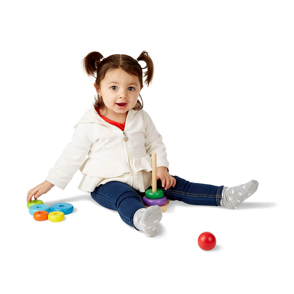 Little girl playing with the Melissa and Doug Rainbow Stacker Classic Toy