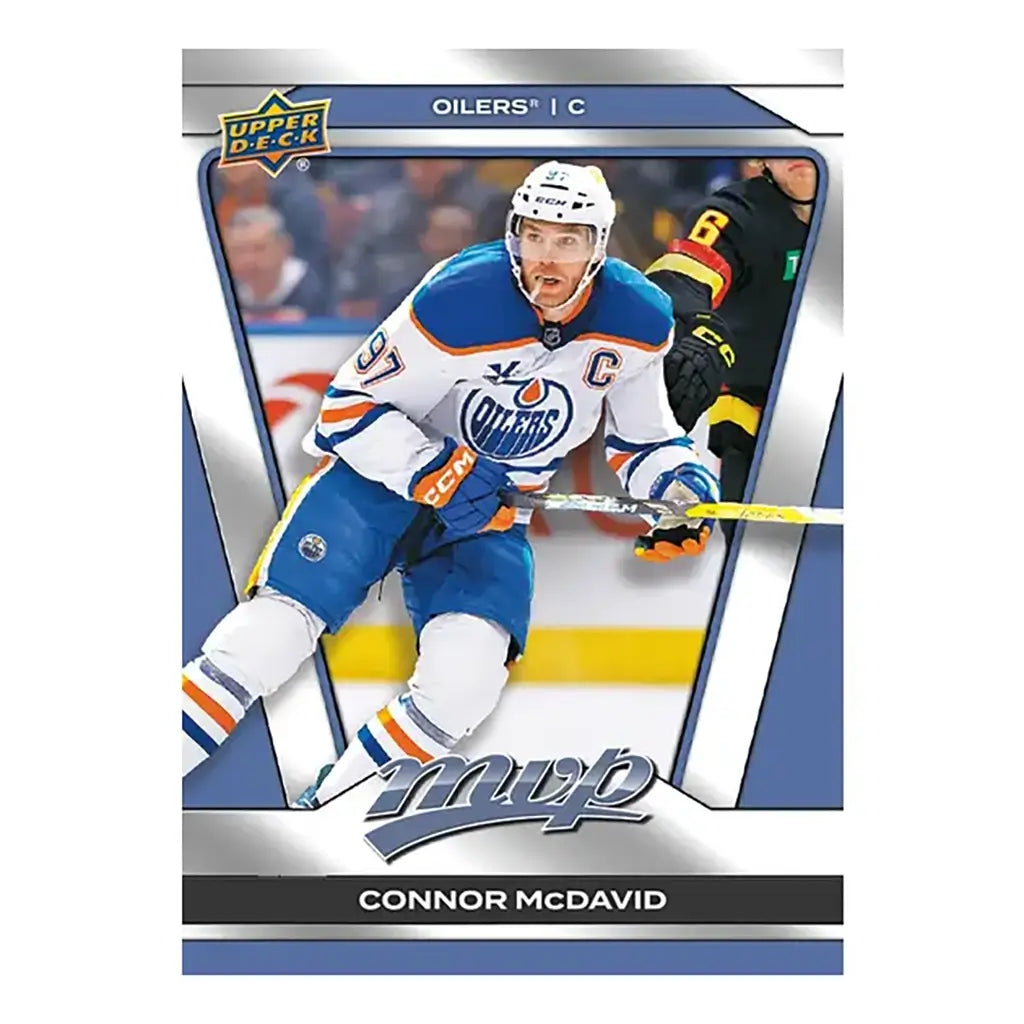 Upper Deck 2025-26 MVP hockey base set card of Connor McDavid in Oilers white jersey with captain’s “C,” mid-action with stick, framed in silver with team and player name.