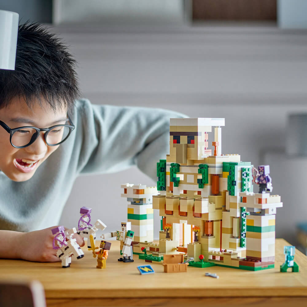 Boy shown playing with the LEGO® Minecraft® The Iron Golem Fortress 21250 Building Toy Set (868 Pieces)