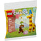 Front of LEGO Creator Birthday Party Animals set 30689 shows a playful scene with a brick-built giraffe wearing a blue party hat and a monkey balancing a birthday cake candle on its head, surrounded by balloons and confetti.