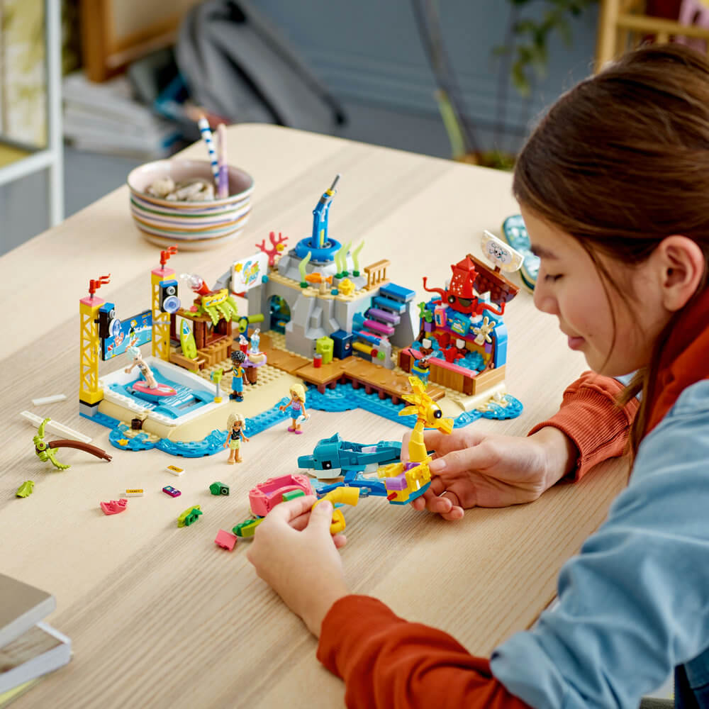Child building the LEGO® Friends Beach Amusement Park 41737 Building Toy Set (1,348 Pieces)