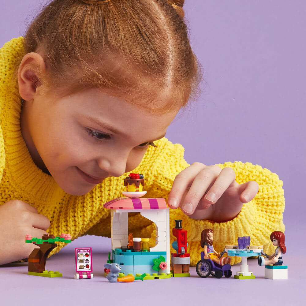 Girl building LEGO® Friends Pancake Shop 41753 Building Toy Set (157 Pieces)