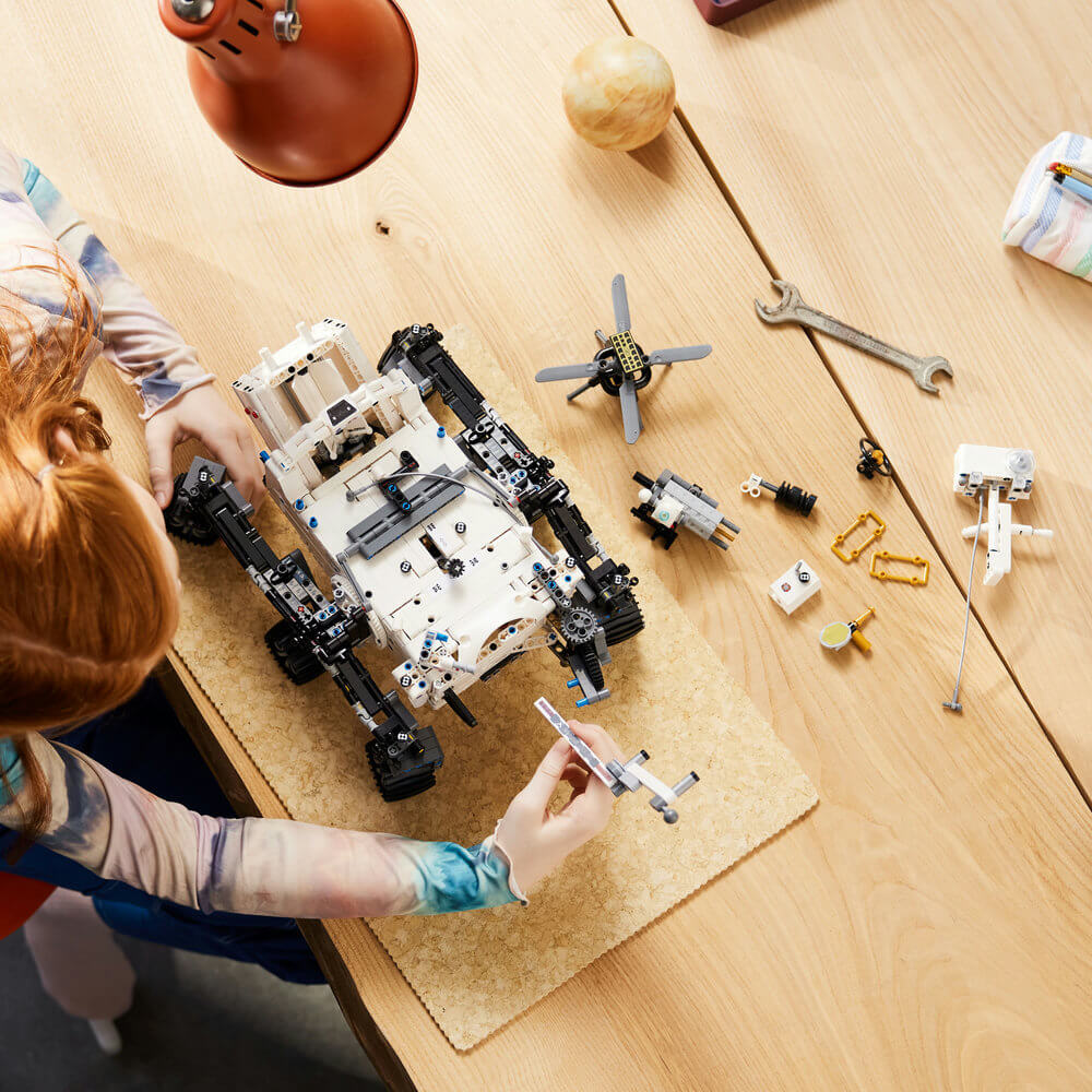 Person shown building the LEGO® Technic™ NASA Mars Rover Perseverance 42158 Building Toy Set (1,132 Pieces)