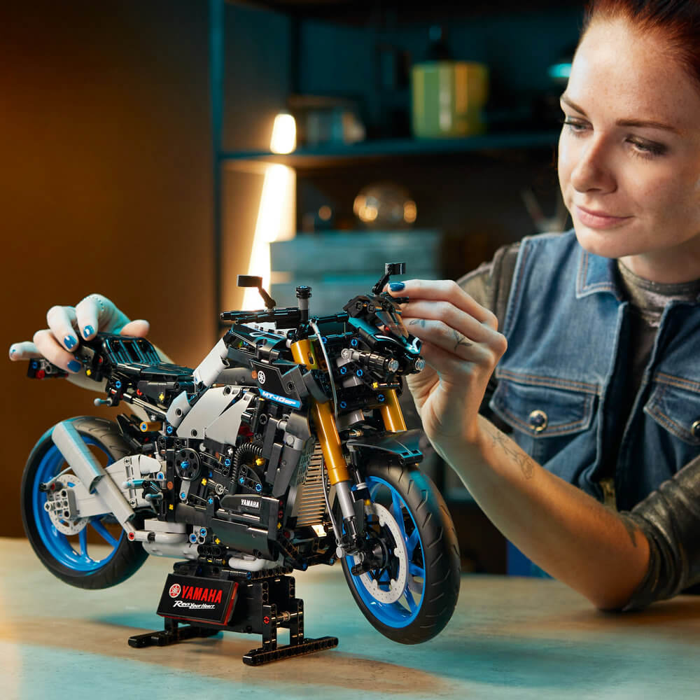Person shown looking at the LEGO® Technic™ Yamaha MT-10 SP 42159; Building Kit for Adults (1,478 Pieces) once it is fully built 