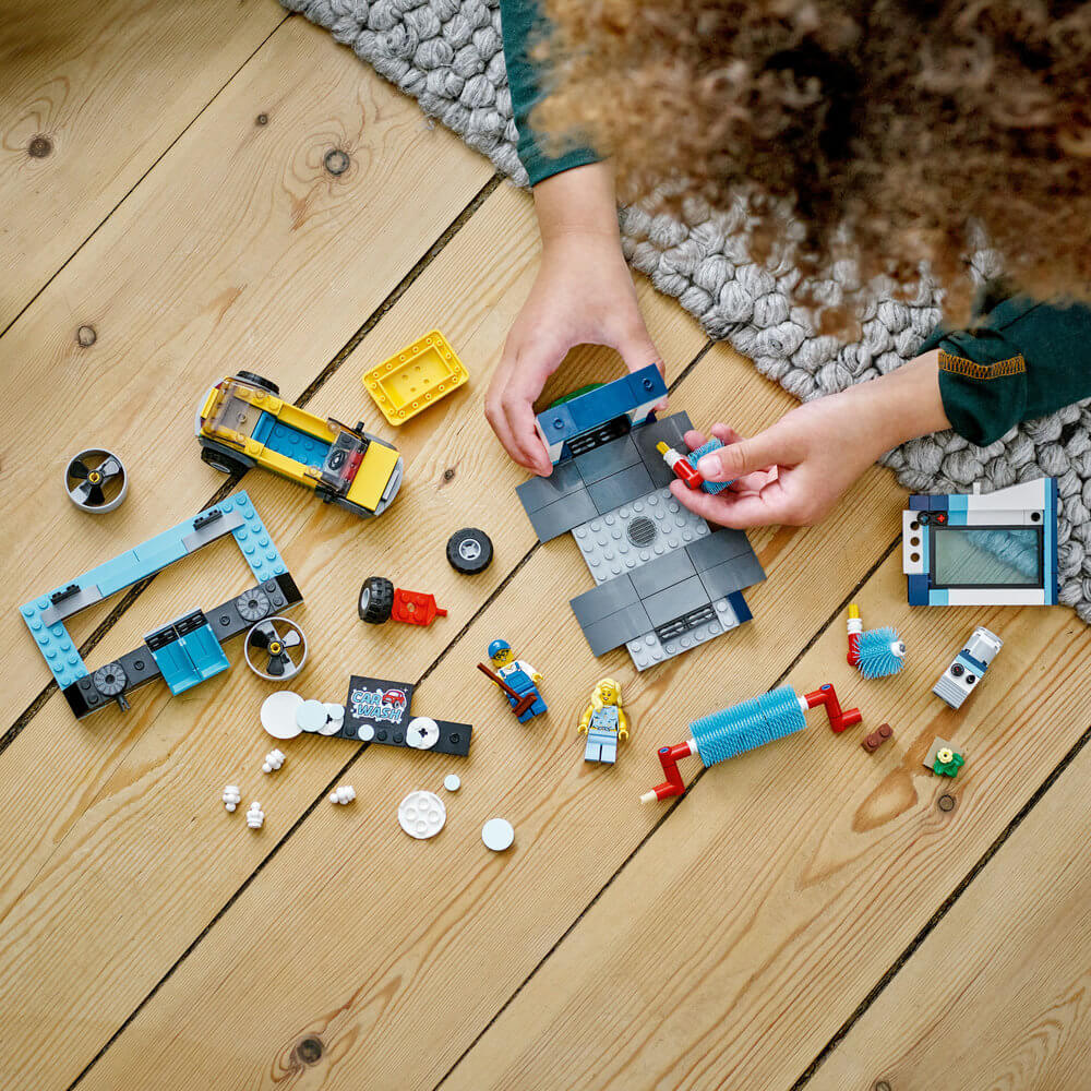 Child building the LEGO® City Car Wash 60362 Building Toy Set (243 Pieces)