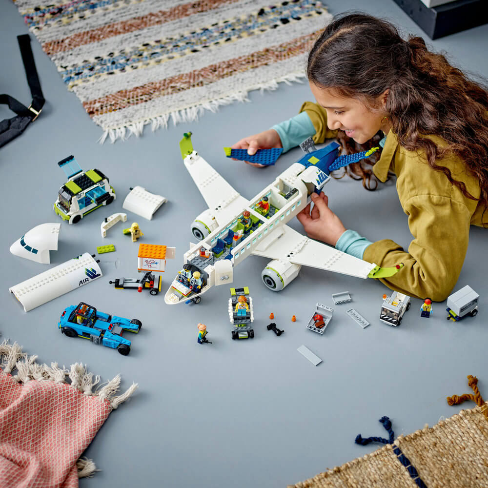 Child building the LEGO® City Passenger Airplane 913 Piece Building Set (60367)