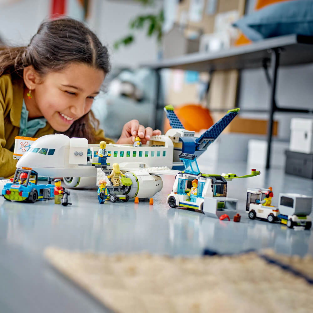 Child playing with the LEGO® City Passenger Airplane 913 Piece Building Set (60367)