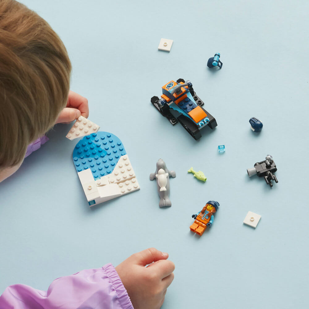 Child building the LEGO® City Arctic Explorer Snowmobile 60376 Building Toy Set (70 Pieces)