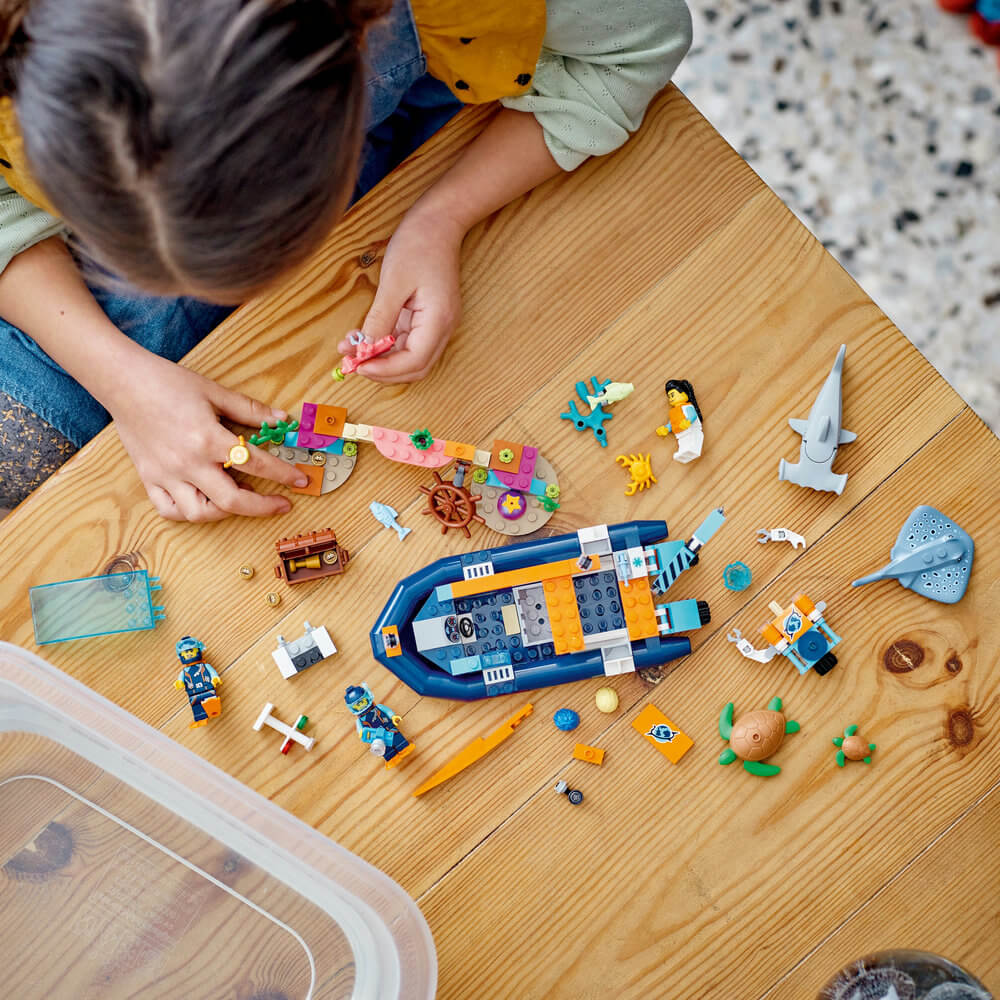 Child building the LEGO® City Explorer Diving Boat 60377 Building Toy Set (182 Pieces)