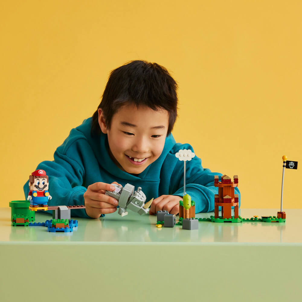 Child smiling and playing with the LEGO® Super Mario™ Rambi the Rhino Expansion Set 71420 (106 Pieces)