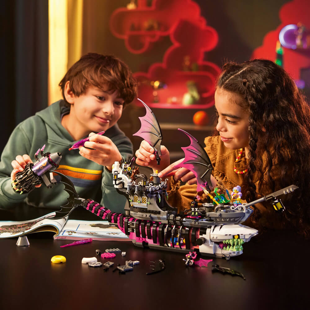 Two kids building the LEGO® DREAMZzz™ Nightmare Shark Ship 71469 Building Toy Set (1,389 Pieces)