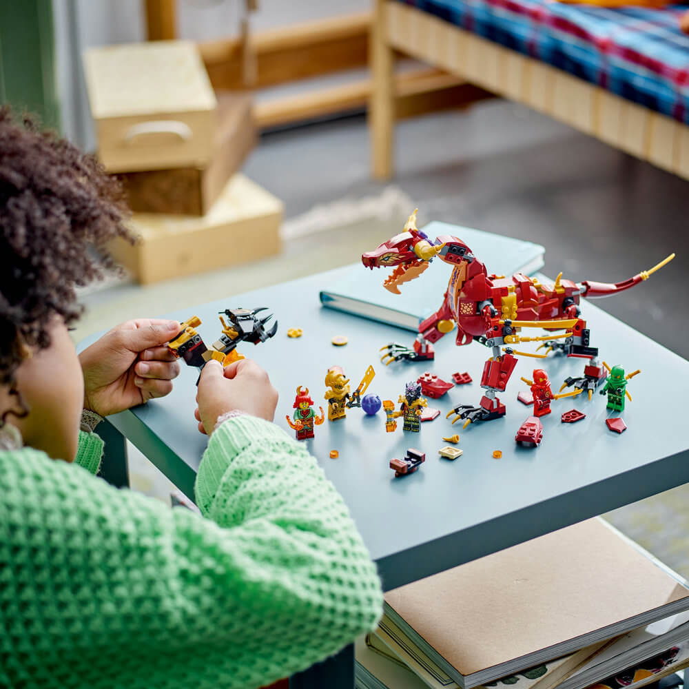 Child shown building the LEGO® NINJAGO® Heatwave Transforming Lava Dragon 71793 Building Toy Set (479 Pieces)