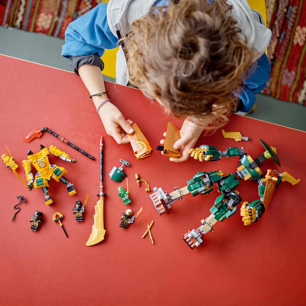 Child building the LEGO® NINJAGO® Lloyd and Arin’s Ninja Team Mechs 71794 Building Toy Set (764 Pieces)
