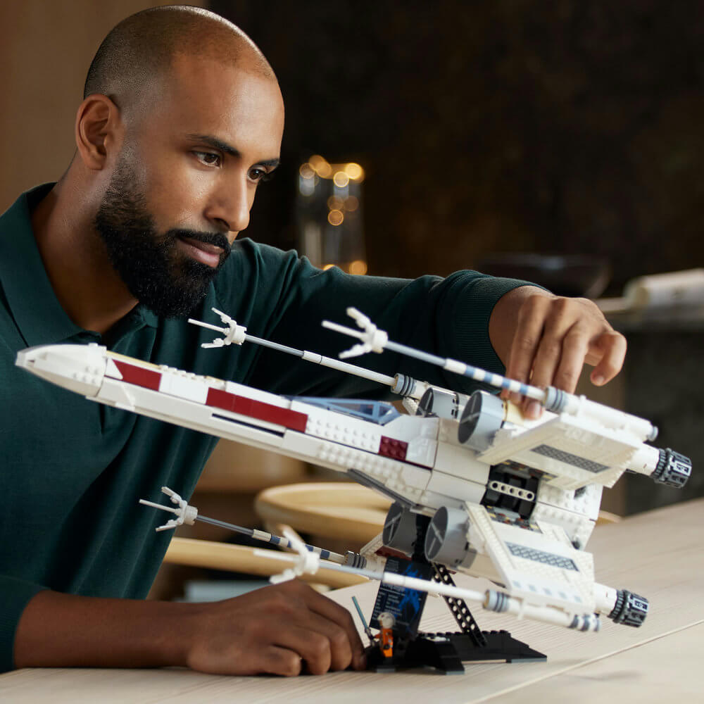 Man looking at the completed LEGO® Star Wars™ X-Wing Starfighter™ 75355 Building Set (1,949 Pieces)