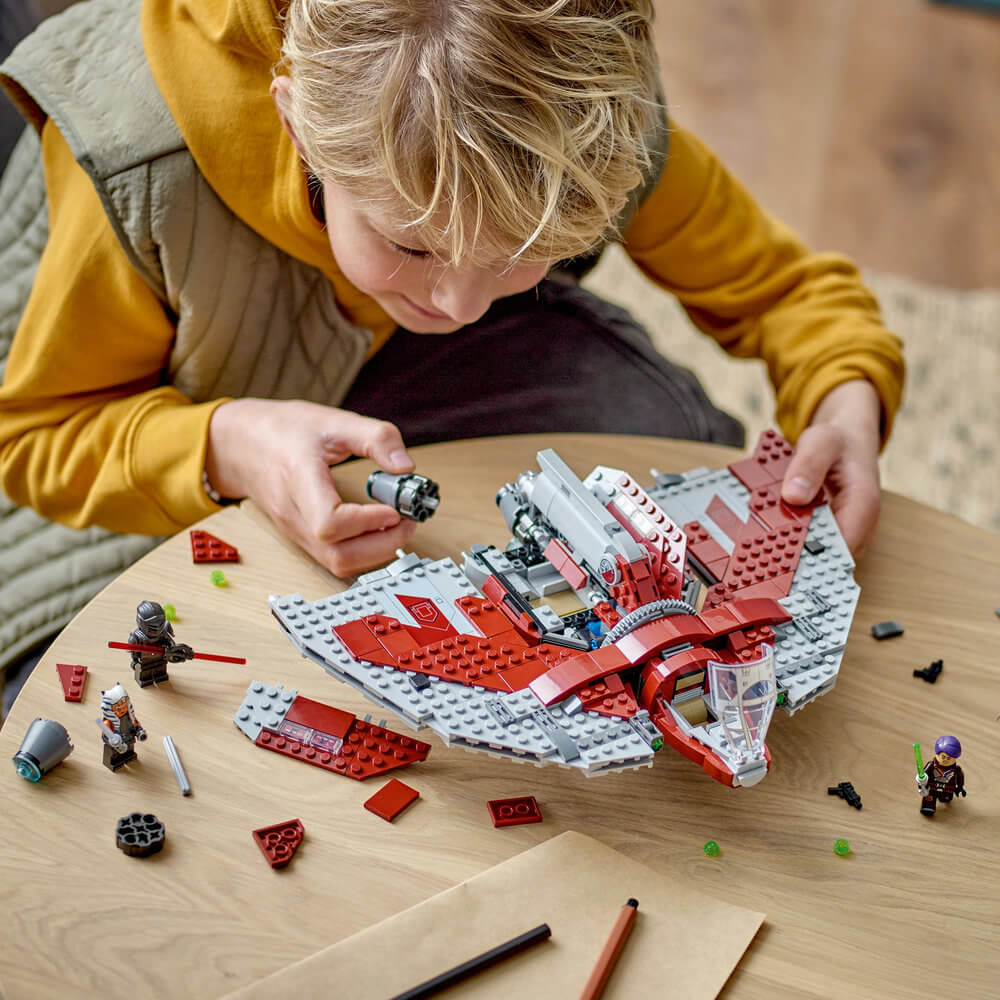 Child shown building the LEGO® Star Wars Ahsoka Tano's T-6 Jedi Shuttle 601 Piece Building Set (75362)