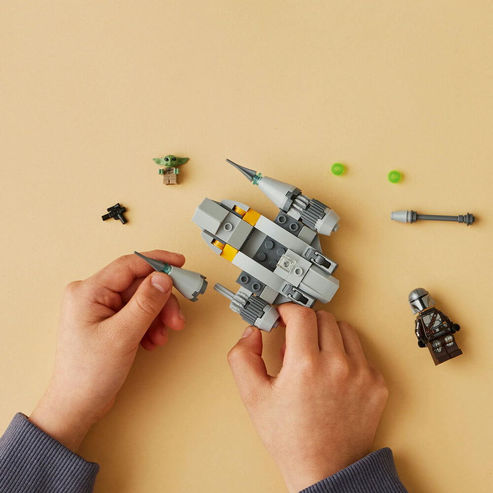 Two hands shown building the LEGO® Star Wars™ The Mandalorian’s N-1 Starfighter™ Microfighter 75363 (88 Pieces)