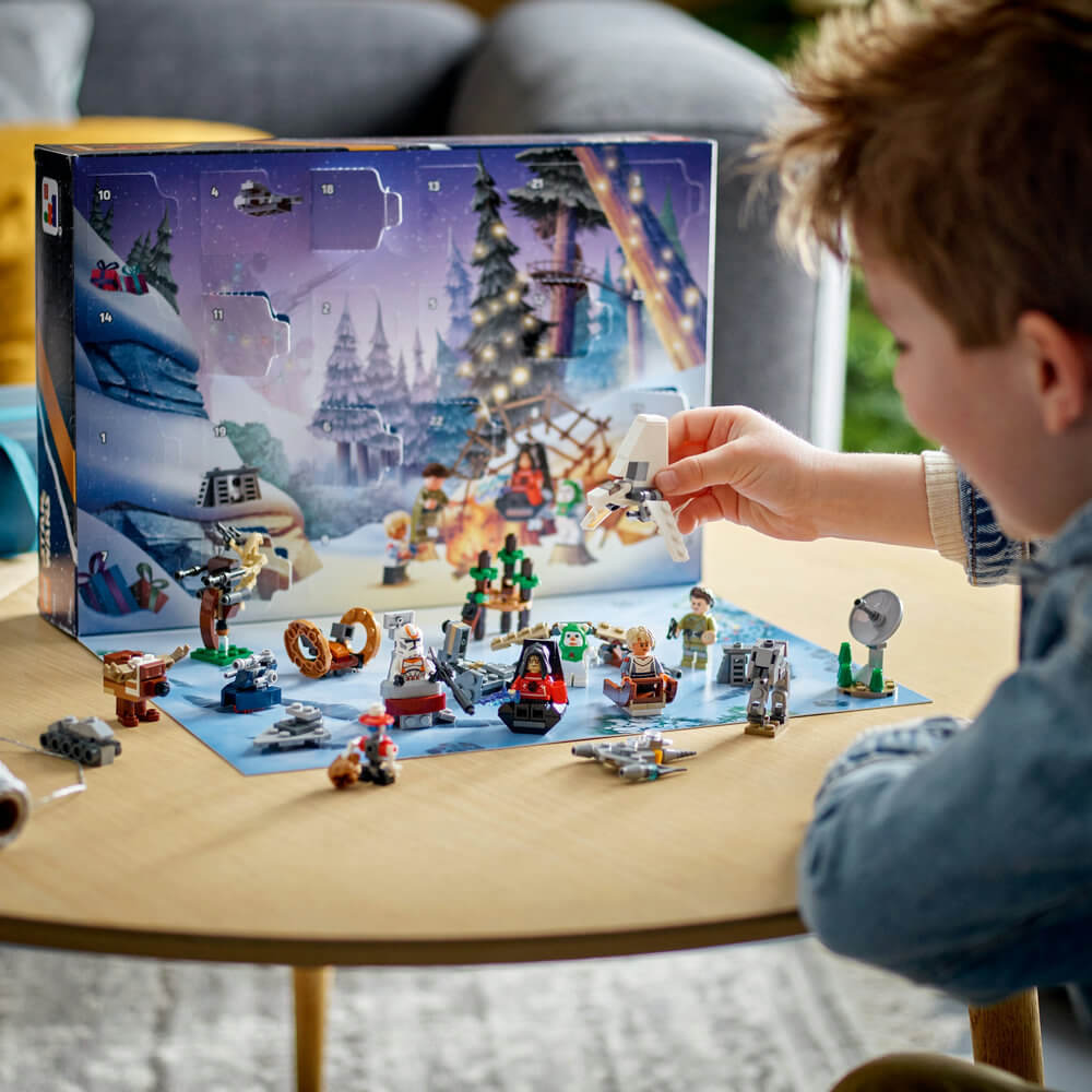 Child shown playing with the LEGO® Star Wars 2023 Advent Calendar 320 Piece Building Set (75366) pieces