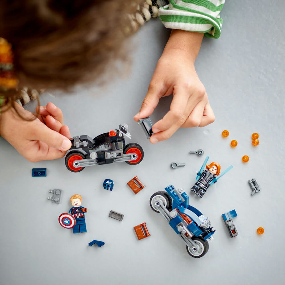 Two hands building the LEGO® Marvel Black Widow & Captain America Motorcycles 76260 (130 Pieces)