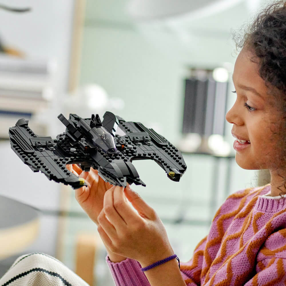 A little girl plahying with the LEGO® DC Batwing: Batman™ vs. The Joker™ 76265 Building Toy Set (357 Pieces)