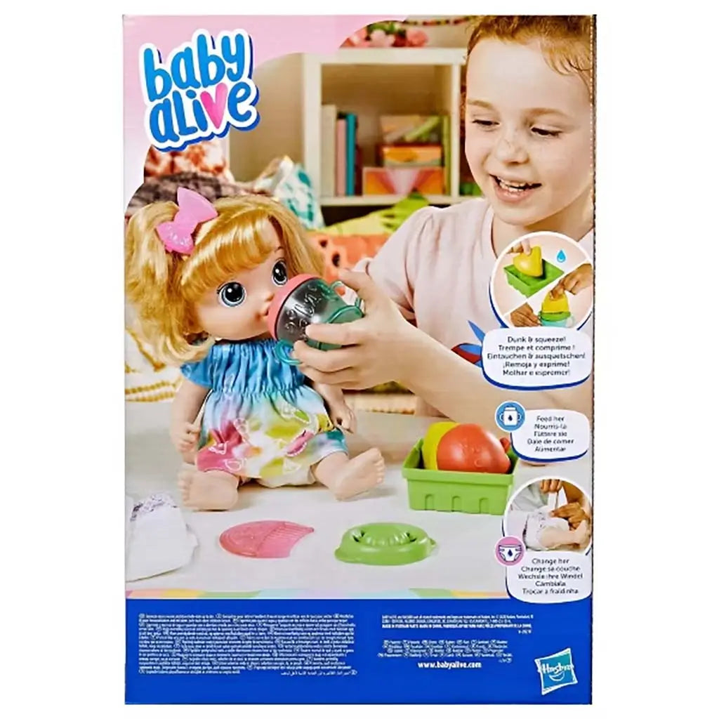 Baby Alive box back showing child feeding the doll with teal cup, fruit accessories, and illustrated instructions for juicing and diaper-change play modes.