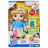 Baby Alive Fruity Sips boxed doll with blonde hair, tie-dye dress, fruit pieces, teal sippy cup, and accessories arranged in yellow open-window packaging.