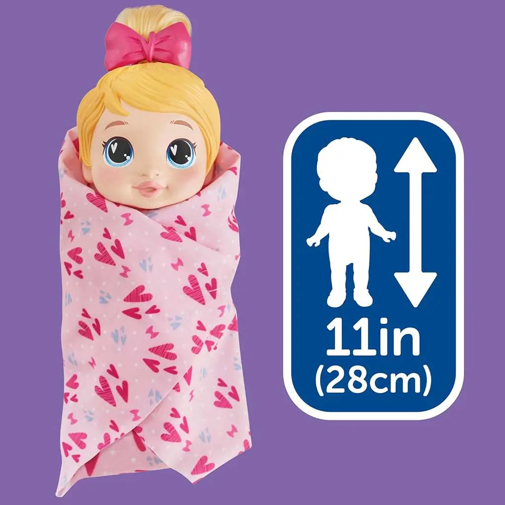Baby Alive Harper Hugs wrapped in pink heart-print blanket beside size graphic showing the eleven-inch doll, emphasizing cuddly styling play against a bold purple background.