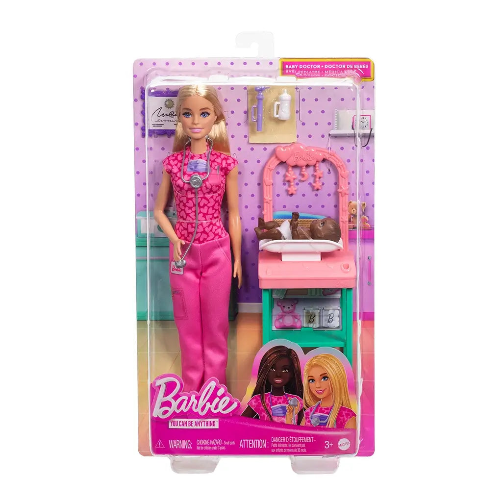 Barbie baby doctor doll playset in retail packaging, featuring blonde doll in pink scrubs, infant doll, pastel exam table, and accessories with “You Can Be Anything” branding.