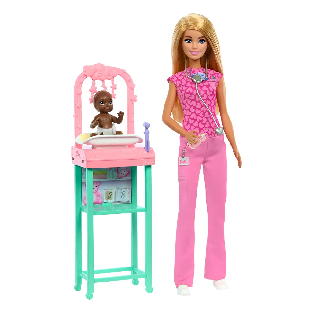 Barbie baby doctor doll in bright pink scrubs with heart print top stands beside a pastel pink and teal nursery station caring for an infant doll, showcasing role-play medical accessories.