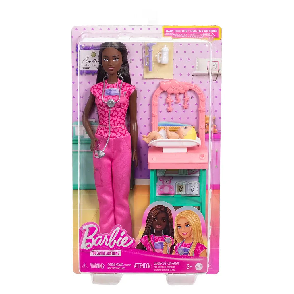 Front packaging of Barbie Baby Doctor doll includes brunette Barbie in pink scrubs with stethoscope, baby doll, medical station, and accessories in a colorful display box.