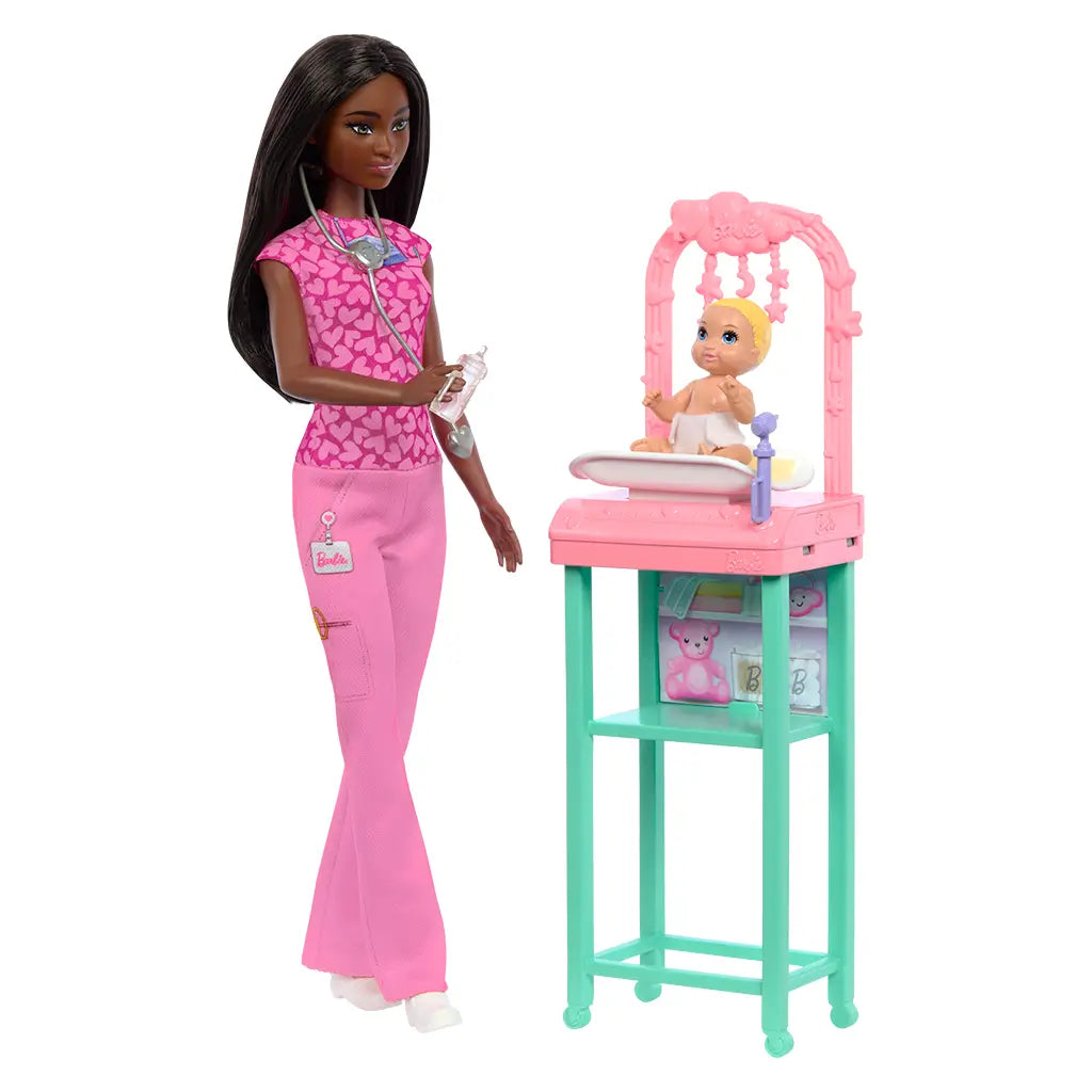 Barbie Baby Doctor doll with medical tools stands next to baby doll lying in pink crib station with teal legs, showcasing pediatric play accessories for interactive storytelling.