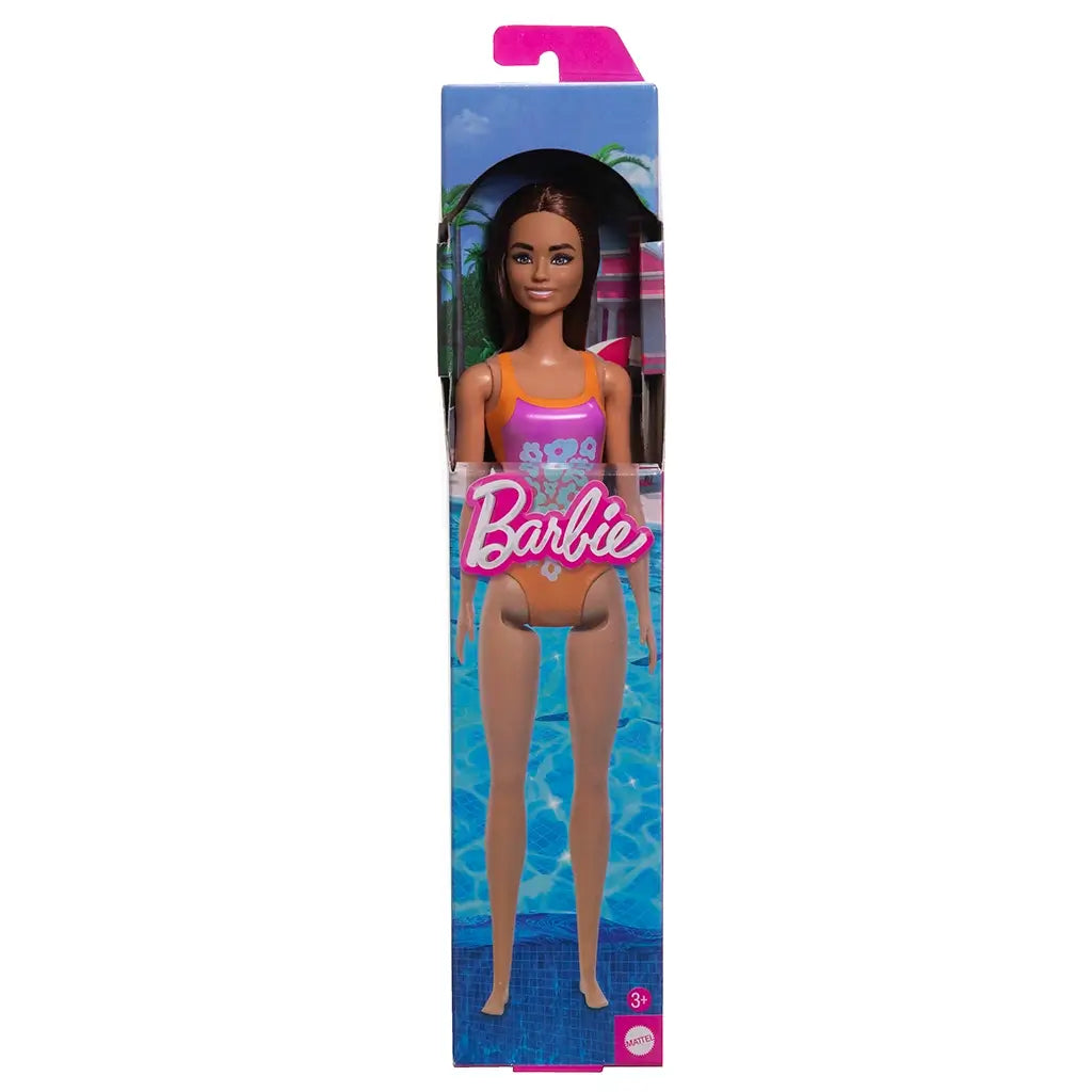 Barbie doll in orange and pink swimsuit with floral design, packaged in a box with a pool background. Suitable for ages 3 and up. Mattel brand.