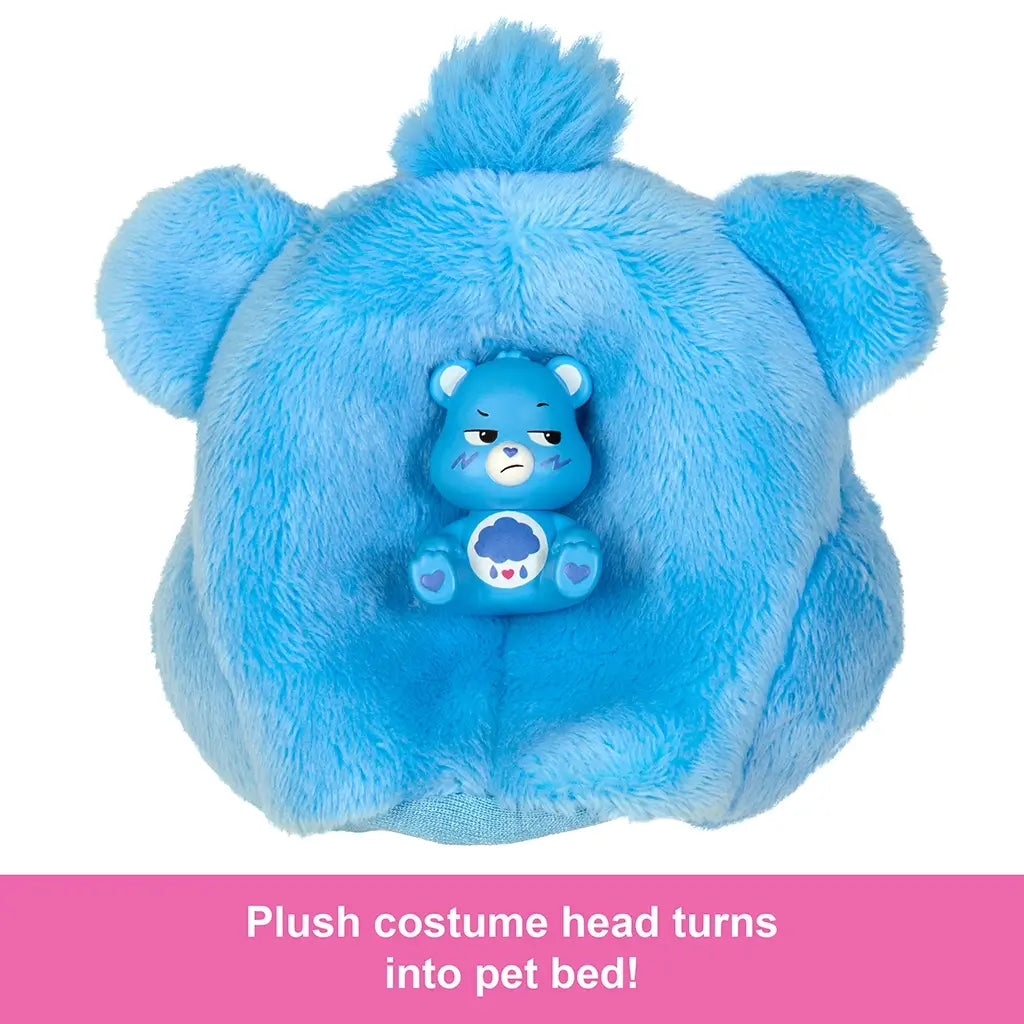 Blue Grumpy Bear plush head from Barbie Cutie Reveal doubles as a pet bed, shown with small collectible Care Bears figure sitting inside for imaginative doll and pet playtime.