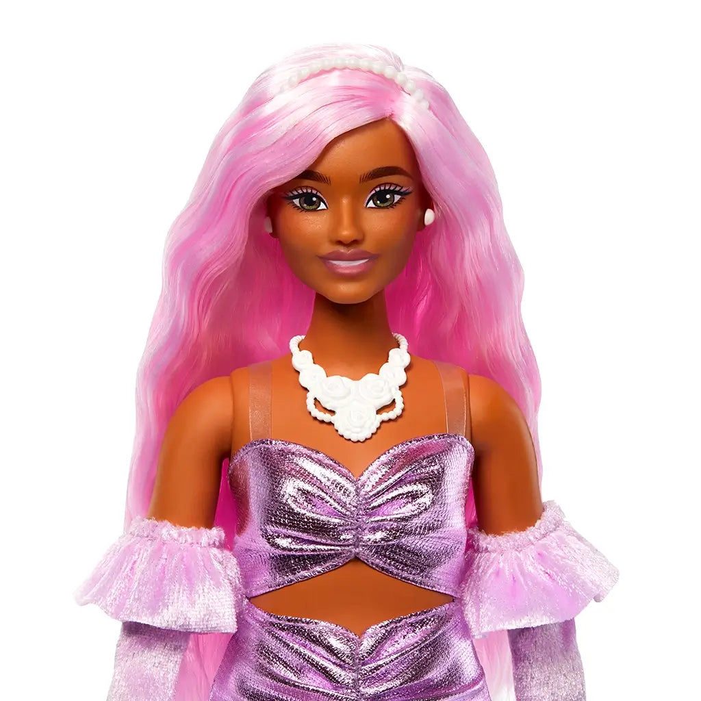 Close-up of Barbie Deluxe doll’s face with long pink hair, wearing pearl earrings, a white rose necklace, and a shiny pink ruched dress with matching gloves.