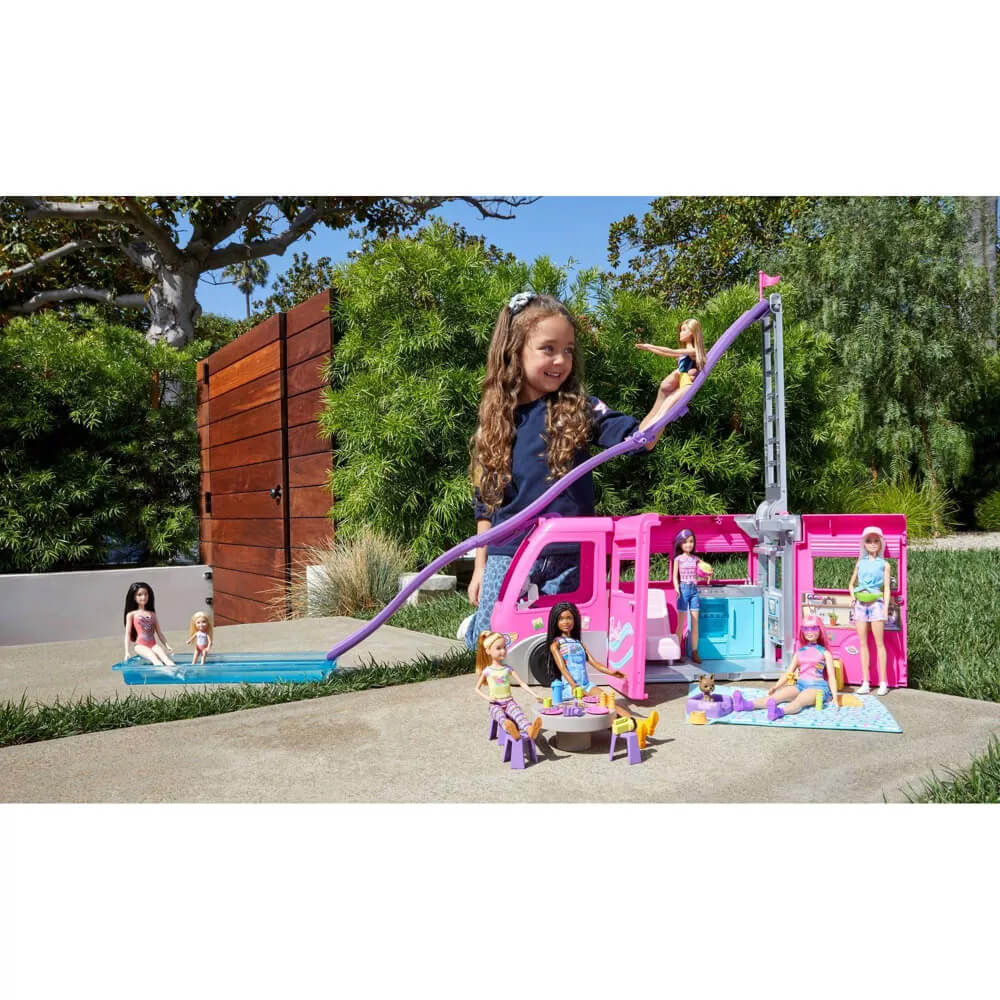 Girl playing with the Barbie Dream Camper Vehicle Playset outside