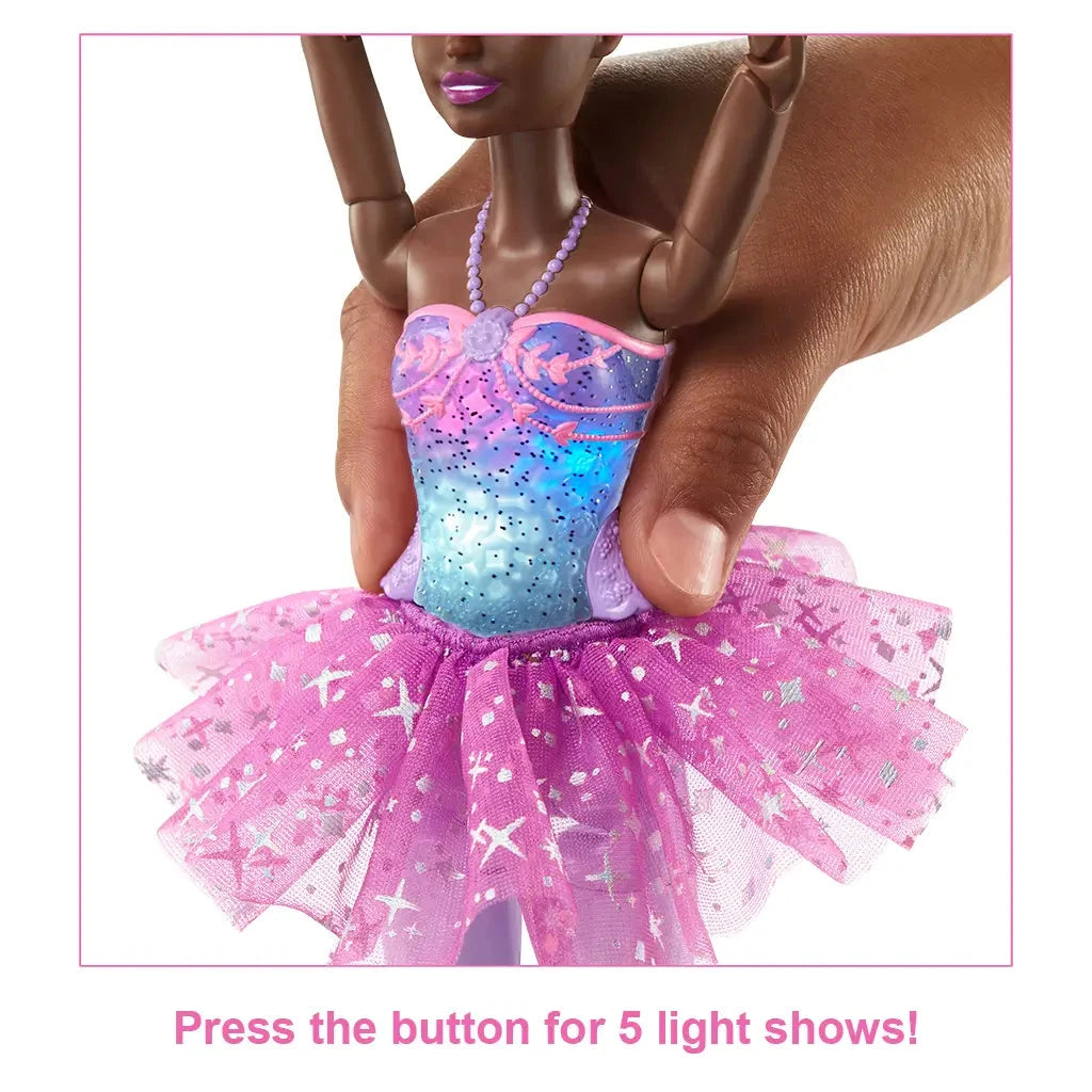 Close-up of Barbie Dreamtopia ballerina doll’s bodice lighting up in blue and pink, with a hand pressing the button to activate one of five colorful light shows.