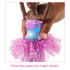 Close-up of Barbie Dreamtopia ballerina doll’s bodice lighting up in blue and pink, with a hand pressing the button to activate one of five colorful light shows.