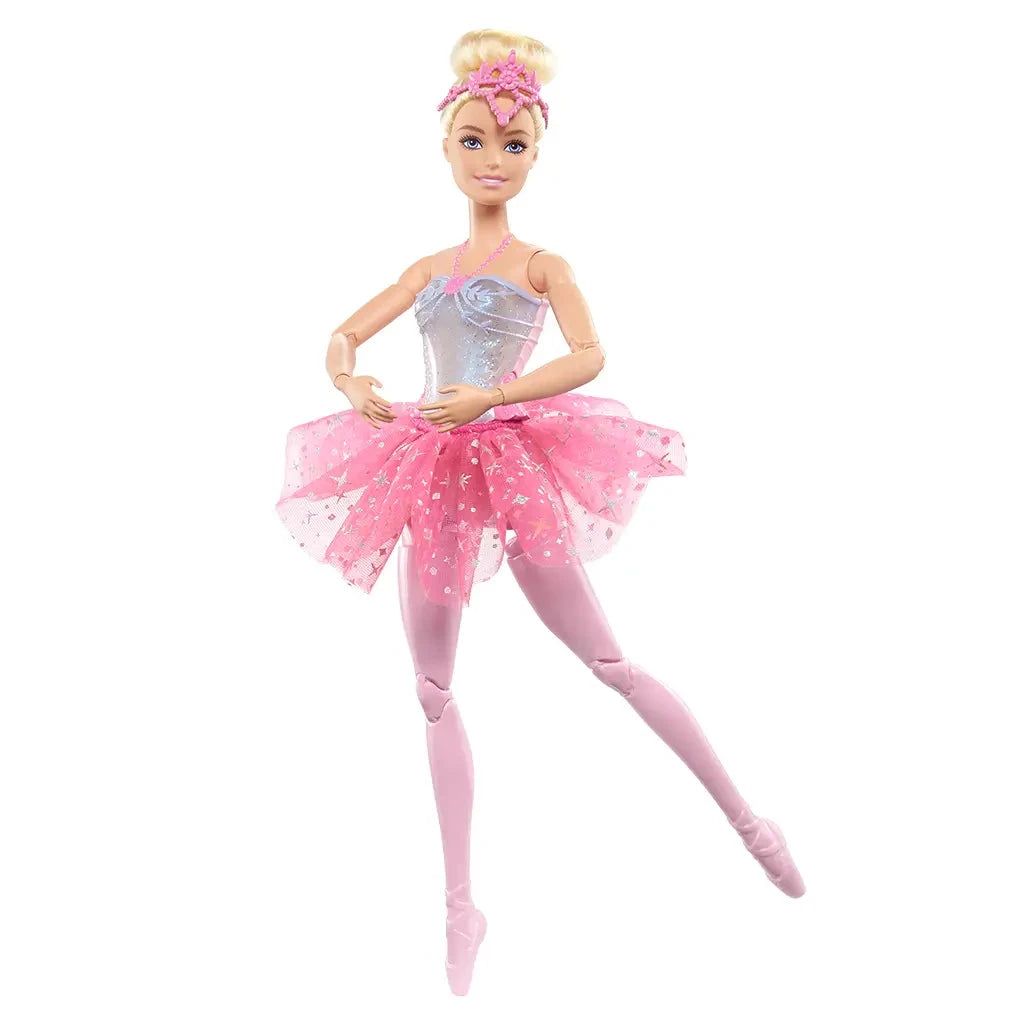 Barbie Dreamtopia Twinkle Lights Ballerina doll posed with arms rounded in front, wearing silver glitter bodice, pink layered tutu, pink tights, and pointe shoes on white backdrop.