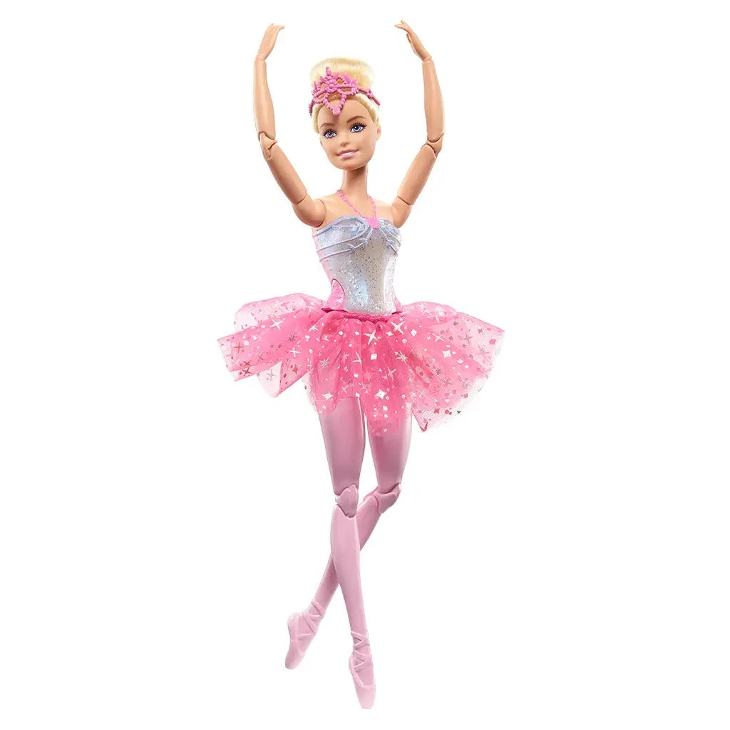 Barbie Dreamtopia Twinkle Lights Ballerina doll stands on tiptoe with arms in ballet fifth position, wearing shimmering silver bodice, pink tutu, tights, and pink pointe shoes.