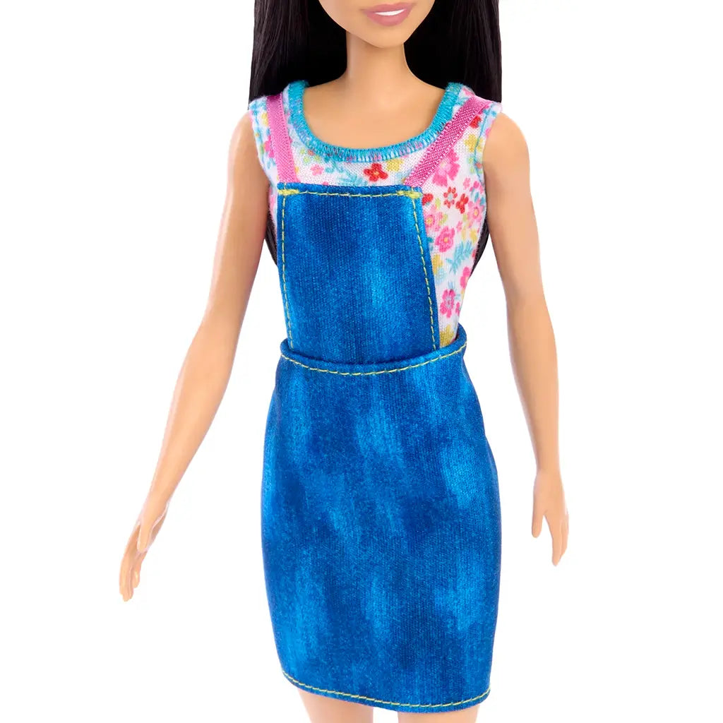 Blue denim overall dress with yellow stitching over a pink and blue floral top, designed for Barbie farmer doll playset. Detailed toy description for collectors and children ages 3 and up.