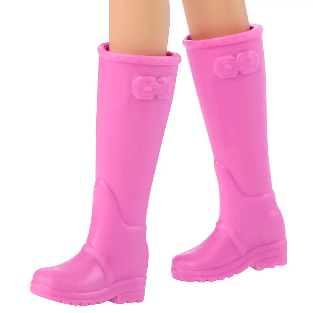 Close-up of tall pink rubber farm boots with bow detail at the top, designed for Barbie farmer doll. Detailed toy description for collectors and children ages 3 and up.