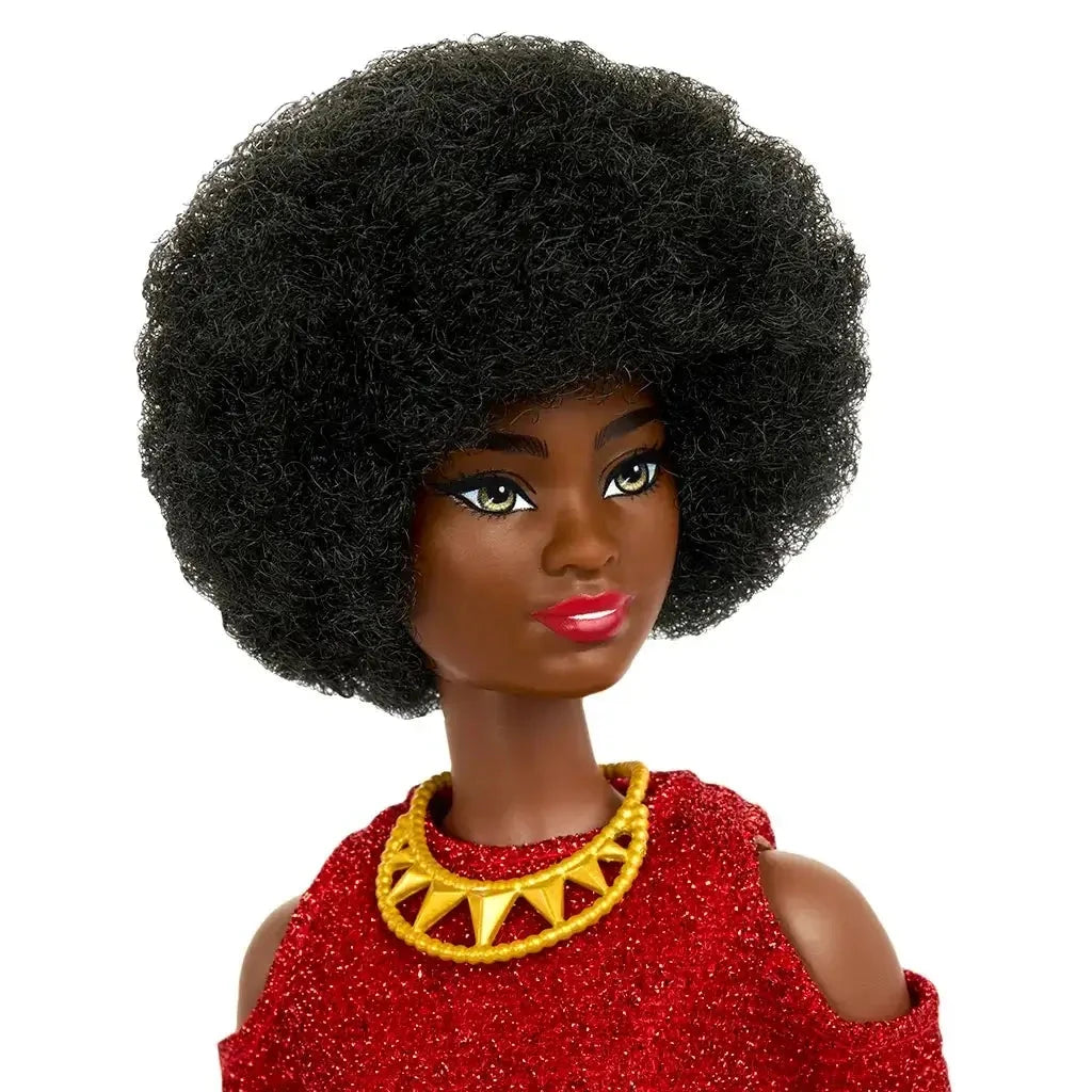 Close-up of Barbie doll with natural textured black afro, gold geometric necklace, and glittery red dress, showcasing her confident expression and vibrant style.