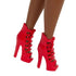 Red patent leather high-heeled lace-up boots with peep toes, worn by a fashion doll, adding a bold pop of color and style against her dark brown skin tone.