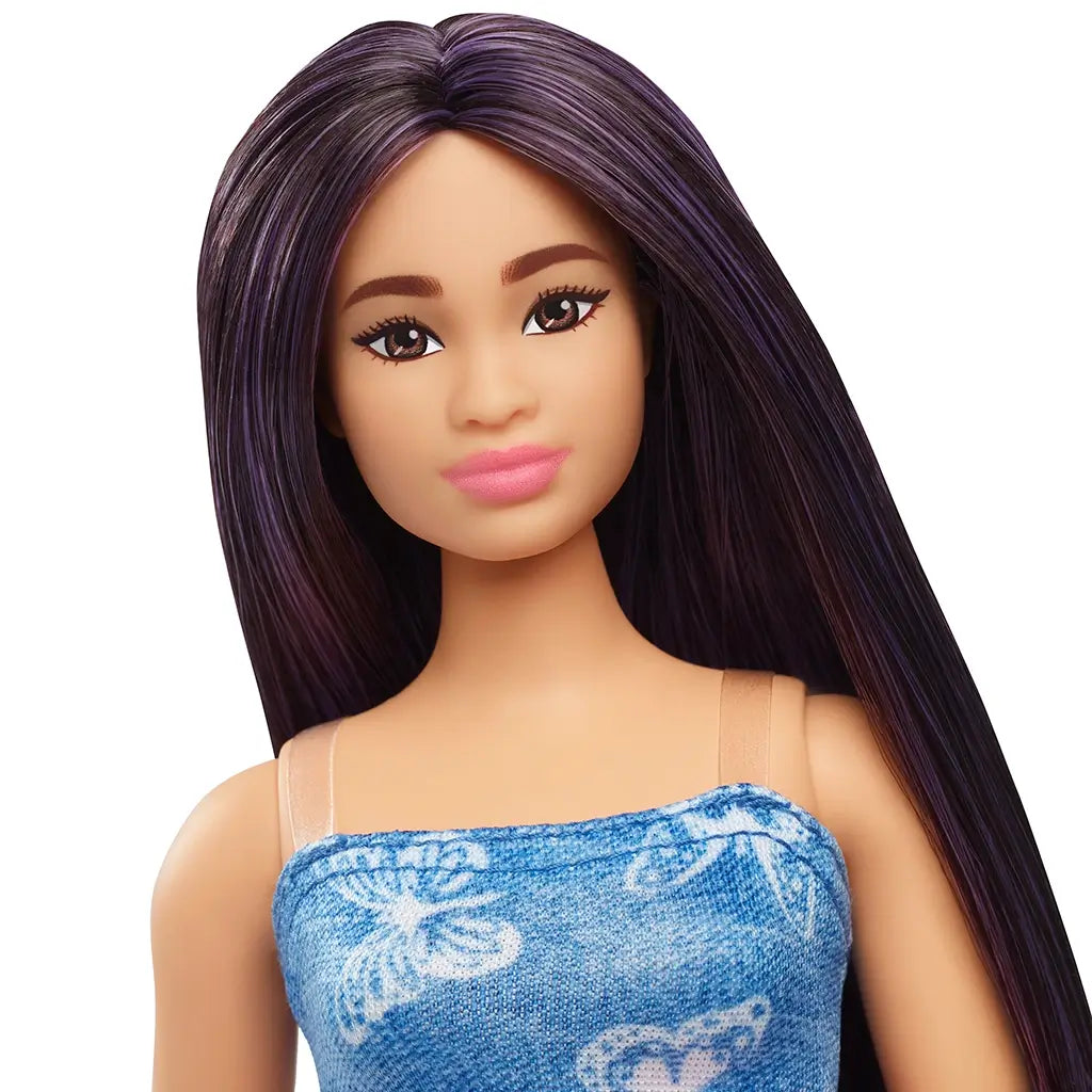 Close-up of Barbie Fashionistas doll with purple-streaked long hair, brown eyes, arched brows, pink lipstick, and butterfly-print denim dress straps visible.