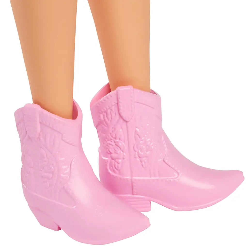 Close-up of Barbie Fashionistas doll’s textured light pink cowboy boots featuring embossed floral details, low heels, and a pointed toe design.