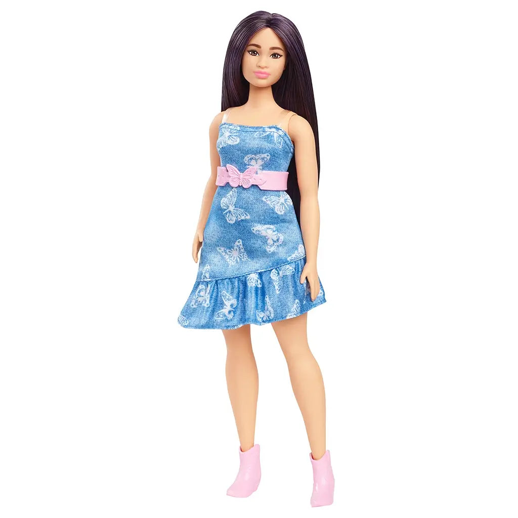 Barbie Fashionistas doll standing upright, wearing a sleeveless denim butterfly-print dress with a pink bow belt, long purple hair, and pink cowboy boots.